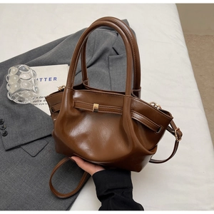 Dettaglio di una borsa tote marrone scuro vintage con texture a pieghe e tracolla