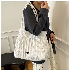 Detailed close-up of large polka dot tote bag with elegant pleated texture for daily use