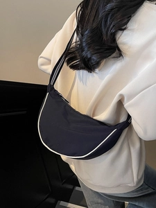 Minimalist navy crescent canvas crossbody bag with striped strap and white piping