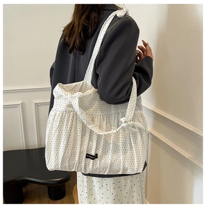 Polka dot canvas tote bag with ruffle trim shown on shoulder for daily styling