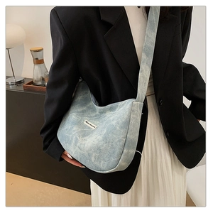 Detail of light blue hobo bag showing denim texture and vintage brand label detail