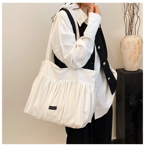 Detail of white pleated tote bag fabric texture with romance label for women