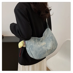Close-up of light blue washed canvas shoulder bag featuring a yellow star plush charm