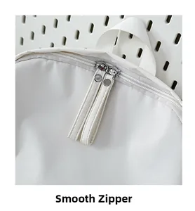 Close-up of high-quality smooth dual zippers on a white minimalist backpack