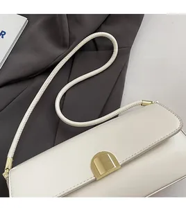 Detail of the minimalist off-white underarm bag with gold buckle and slim strap