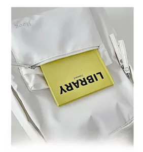 Detailed macro view of the front pocket of a white leather backpack showing storage capacity