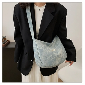 Detailed shot of light blue corduroy crossbody bag showing large capacity and fabric texture