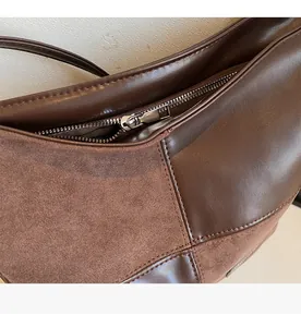 Detail of smooth silver metal zipper and fine stitching on a dark brown velvet handbag