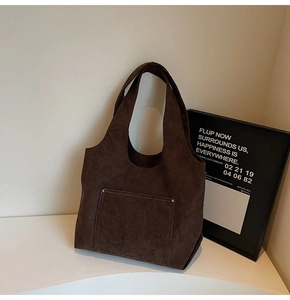 Detail of dark brown corduroy tote bag featuring striped texture and a large front pocket