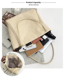 Detalle del interior de un bolso tote beige grande con portátil y artículos personales
