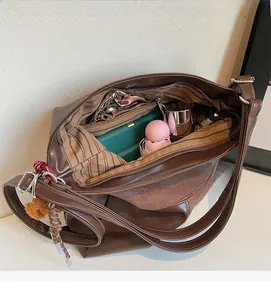 Detail view of large tote bag interior with striped lining and multiple storage items