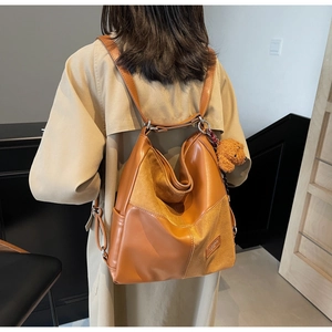 Detailed back view of a caramel velvet and leather tote bag with a teddy bear charm