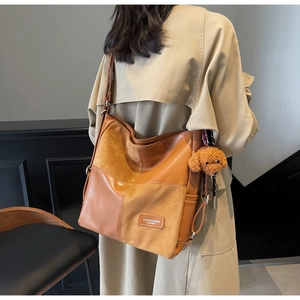 Detail of vintage patchwork tote bag in tan leather with cute teddy bear charm pendant