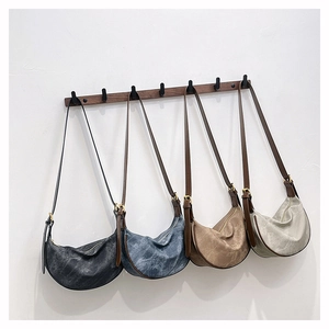 Detail view of retro crescent crossbody bags in four colors with vintage leather texture