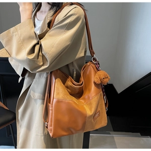Detail of caramel brown velvet and PU leather patchwork tote bag with plush puppy charm