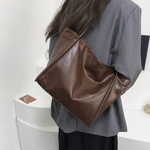 Modelo con bolso tote vintage marrón oscuro en cuero sintético mate de alta calidad
