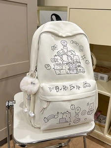 Cute white canvas backpack with cartoon illustrations and plush charm on a metal chair