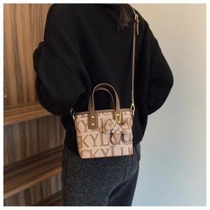 Detail der Trend-Tote-Bag mit Lucky-Print, Hundeanhänger und Schultergurt am Modell