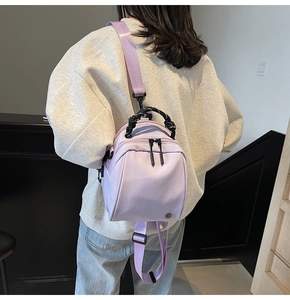 Detail van de lavendel mini-tas met geweven handvatten en brede schouderriem