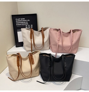 Close-up of four colors of large tote bags with twill texture and leather handles