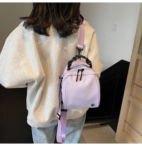 Lavender purple mini shell backpack with thick braided handle on female model