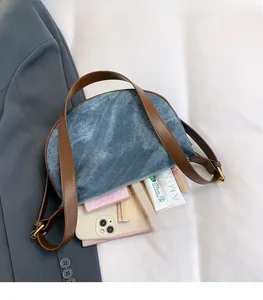 Detail view of denim dumpling bag interior showing spacious capacity for daily essentials