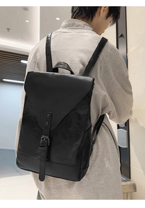 Detailansicht des schwarzen Retro-Rucksacks mit Klappe und Schnallenverschluss am Model
