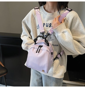 Close-up of a lilac nylon mini shell bag worn as a trendy chest pack with striped handle