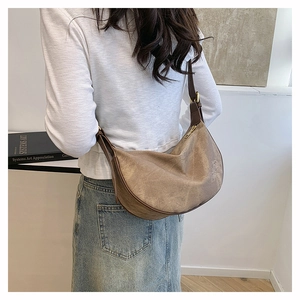 Detail of vintage dumpling bag featuring brown canvas texture and adjustable leather strap