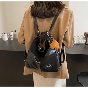 Detail of black patchwork tote with bear charm and fashion leather brand label