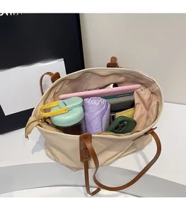 Top view of spacious cream tote bag interior showing tablets, umbrellas, and daily essentials