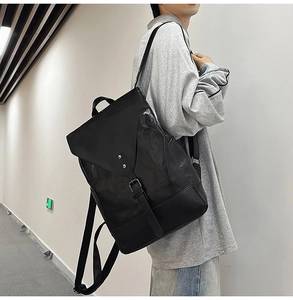 Seitenansicht eines schwarzen Lederrucksacks mit Klappe und Retro-Schnalle im Vintage-Stil