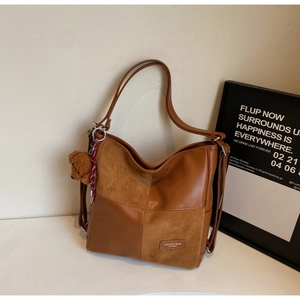 Detailed view of the dark brown PU leather and suede patchwork tote with a cute bear charm