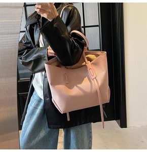 Detailed view of pink tote bag with vertical ribbed texture and slim shoulder straps
