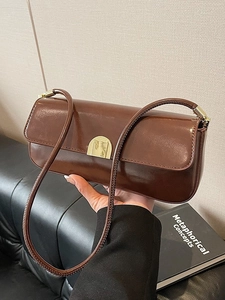 Minimalist brown underarm shoulder bag with glossy finish and gold buckle hardware