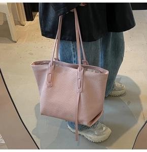 Detail of pink tote bag with diagonal twill texture and slim double shoulder straps