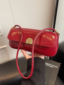 Minimalist red leather underarm bag with gold metal buckle and sleek shoulder strap
