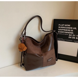 Detail of vintage patchwork hobo bag featuring smooth leather and suede textures