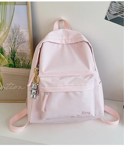 Detail of light pink nylon backpack with Hoog branding and silver bear keychain