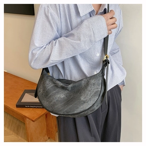 Detail of vintage grey moon bag showing the aged faux leather texture and gold hardware
