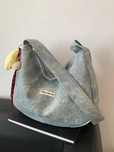 Light blue wash denim hobo bag with quilted stitching and cute plush chick charm