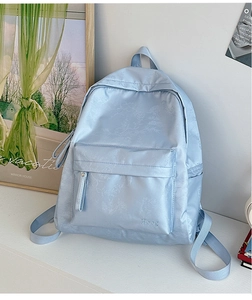 Detail of light blue satin backpack with floral jacquard texture and front pocket zipper