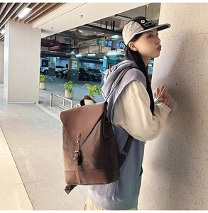 Brauner Vintage-Rucksack aus Kunstleder mit Happy-Logo, präsentiert von einem Model