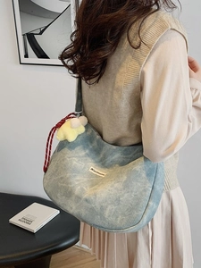 Blue tie-dye canvas shoulder bag with star plush pendant and woven strap details