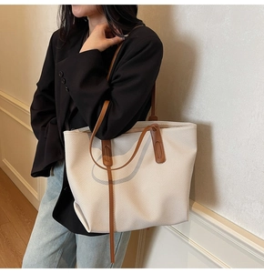 Detail of woven tote bag showing beige texture and dark brown leather strap connections