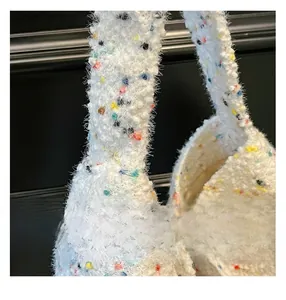 Nahaufnahme der weißen flauschigen Stricktasche mit bunten gesprenkelten Garndetails