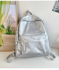 Detail of silver gray backpack with elegant bamboo leaf patterns and smooth metallic texture