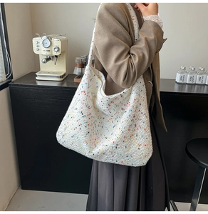 Detail einer weißen Stricktasche mit bunten Punkten in gemütlicher Café-Atmosphäre
