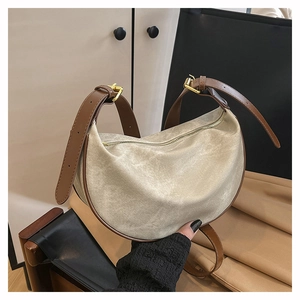 Detail of canvas crescent crossbody bag showing textured fabric and leather strap