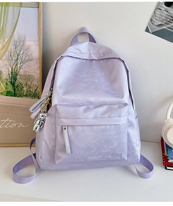 Detail of lavender satin backpack with floral texture, Hoog embroidery and bear charm